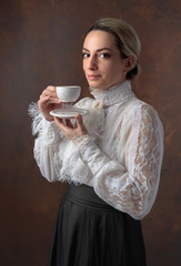 Portrait of a woman in Victorian clothes with a cup of coffee.
