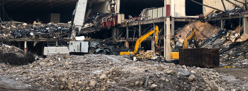 Demolition team machines demolishing a big factory
