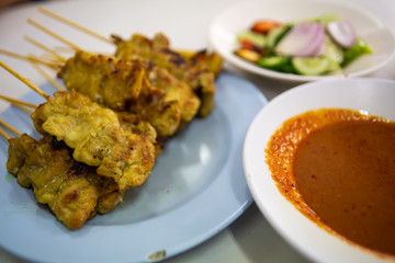 Pork Satay with your Peanut Sauce and pickles which are cucumber slices and onions in vinegar,  Close up & Macro shot, Selective focus