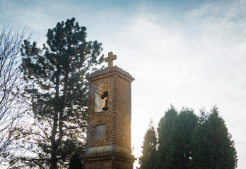 Small old church tower in the sunlight with sky in background