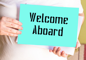 Welcome Aboard on green paper holding bay person