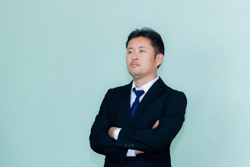 A studio image of an Asian businessman with a handsome beard and a mint green background