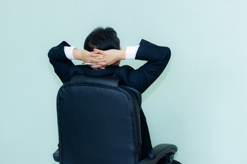 A studio image of an Asian businessman with a handsome beard and holding pen a mint green background