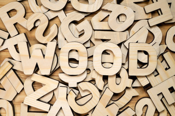 Board covered with random wooden letters and word WOOD on top.