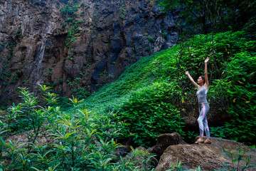 relaxed young woman with backpack standing by the stream. Female hiking by the creek India Karnataka Kerala