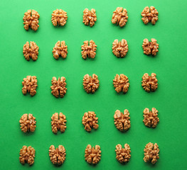 Tasty shelled walnuts on color background