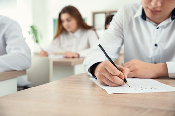 Pupils passing school test in classroom