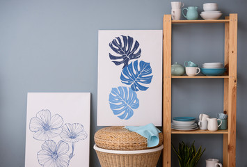 Set of clean dishes on wooden shelves near color wall