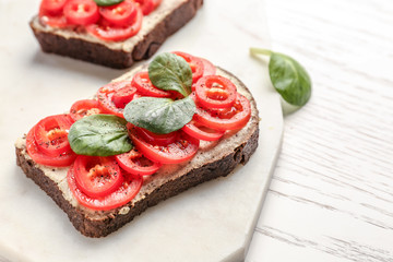 Fresh tasty bruschetta on white board, closeup