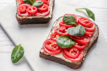 Fresh tasty bruschetta on white board, closeup