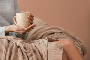 Young woman drinking hot tea at home, closeup