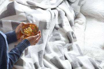 Young woman drinking hot tea at home