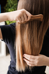 Young woman combing her long hair