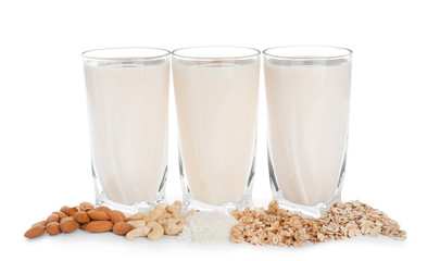 Glasses of different vegan milk on white background