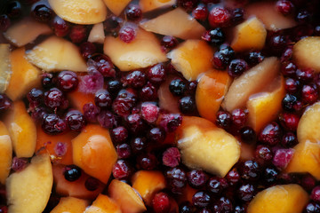 The texture of the juice from the berries and apples. Boil fruit and berry compote for healthy nutrition. Background in the form of boiled apples and berries for juice.
