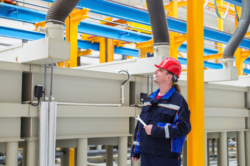 Worker in a factory looking up in factory machines