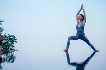 Obraz na płótnie Canvas Beautiful woman practice yoga pose on the infinity pool above the mountain peak in the morning in front of beautiful nature views in india goa wildernest nature resorte .romance sunrise in mountains