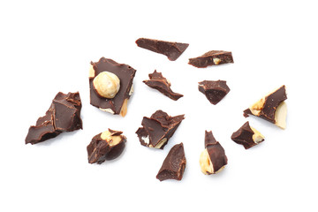 Pieces of tasty dark chocolate with nuts on white background