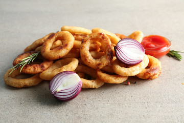 Tasty onion rings on table
