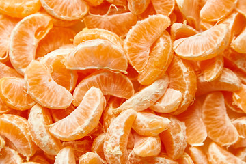 Slices of peeled tangerine. Mandarin section segment background. Citrus fruit