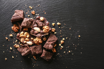Sweet tasty chocolate with nuts on dark background