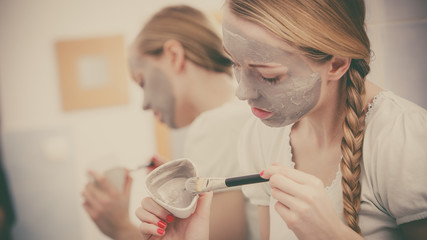 Woman with grey clay mud mask on her face