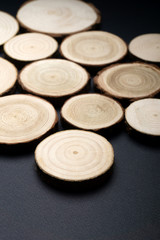 Pine tree cross-sections with annual rings on plane black surface. Lumber piece close-up shot.