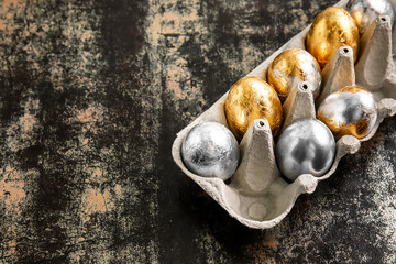 Holder with beautiful Easter eggs on dark background