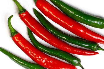 Green and red chili peppers on white background, top view. Hot spicy food symbol.