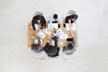 Top view of businessmen shaking hands sitting at conference table during team meeting, Entrepreneurs handshaking making deal starting collaboration at group negotiations teamwork with blank copy space