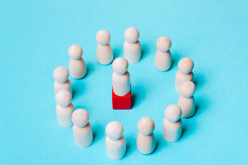 Wooden figures on a blue background. Leader and team.