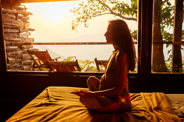 pregnant woman in tropical yoga studio place a view outside to the hills while sunset.girl in eco...