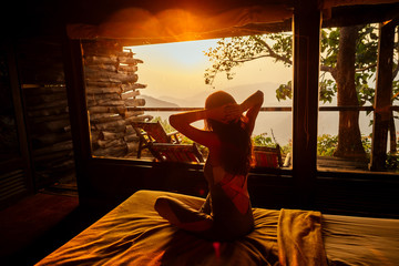 Young woman on f the house in the beautiful forest panoramic windows eco hotel in the jungle