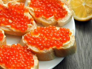 Red caviar on sandwiches on a wooden table