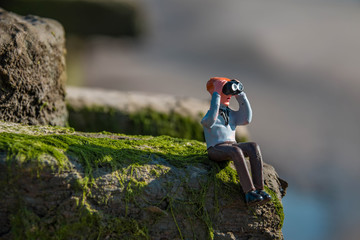 Miniatur Figur Mann sitzt im Gras und schaut durch ein Fernglas (no brand)