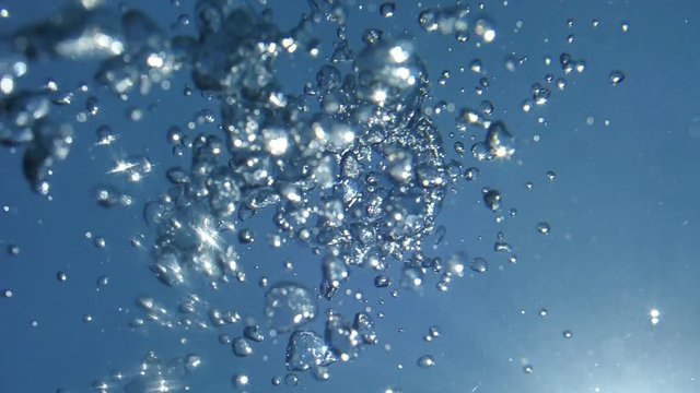 Natural Light Rays in Pure Life Water, Shining Through the Air's Glittering and Moving Bubbles