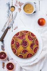 Upside down blood orange cake on old light wooden background. Rustic stile. Selective focus