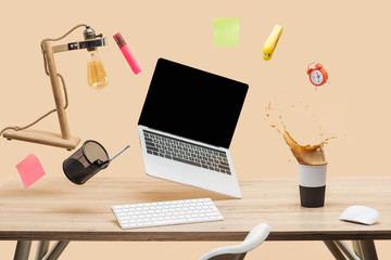 laptop with blank screen, lamp, empty sticky notes and stationery levitating in air above workplace...