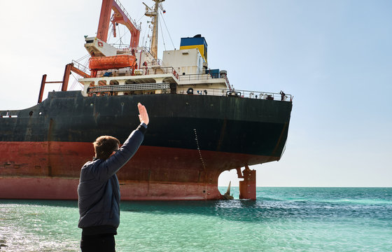 A Man Waving To The Sailors On The Ship. Cargo Ship Rio Ran Aground Off The Coast Of Novorossiysk