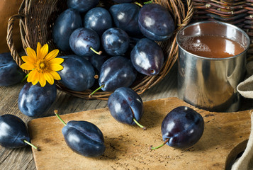 Plum juice in a mug and plums
