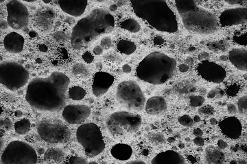 The holes on the porous sponge for washing dishes close up black and white - obrazy, fototapety, plakaty