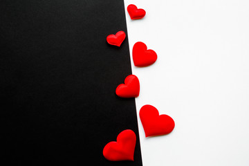 Bright red textile hearts in middle on black and white paper background. Fight between love and...