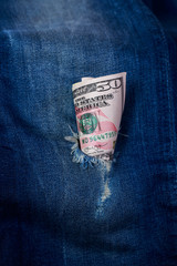 Dollars in a denim hole