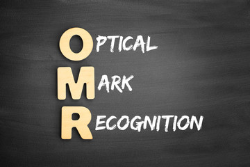 Wooden alphabets building the word OMR - Optical Mark Recognition acronym on blackboard