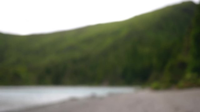 young girl smoking vape in nature and blowing smoke into the camera