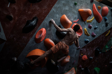 Fototapeta na wymiar Athletic man practicing in a bouldering gym
