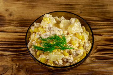 Festive salad with chicken breast, sweet corn, canned pineapple, cheese and mayonnaise on wooden table