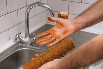 Hand holding dirty water filter cartridge over the sink. Brown coloring. Evidence of contamination...