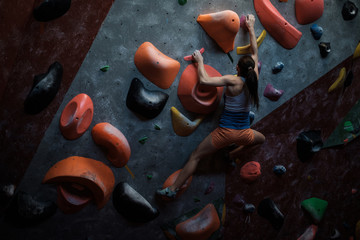 Athletic woman practicing in a bouldering gym