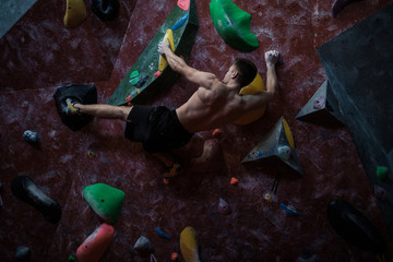 Athletic man practicing in a bouldering gym
